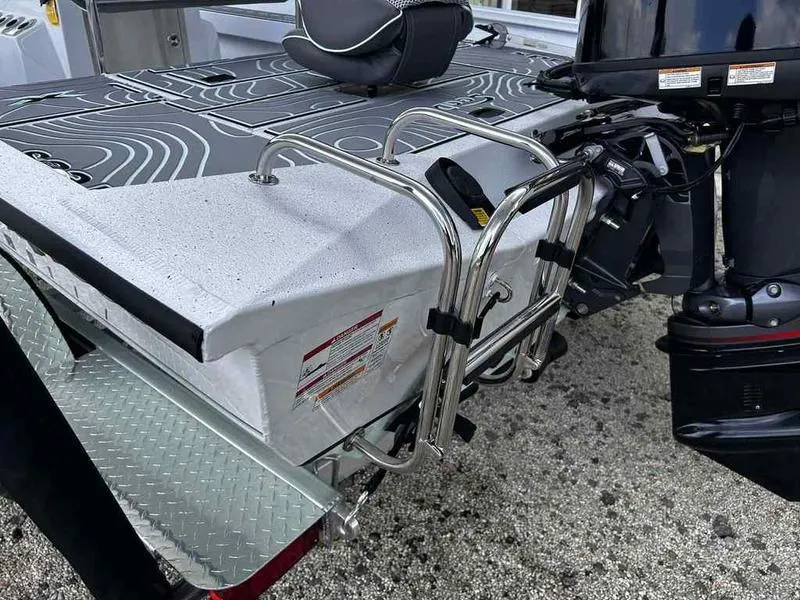 Slide: The Image of 2025 Xpress H20 BAY boat with motor and ladder on a textured surface. - 11
