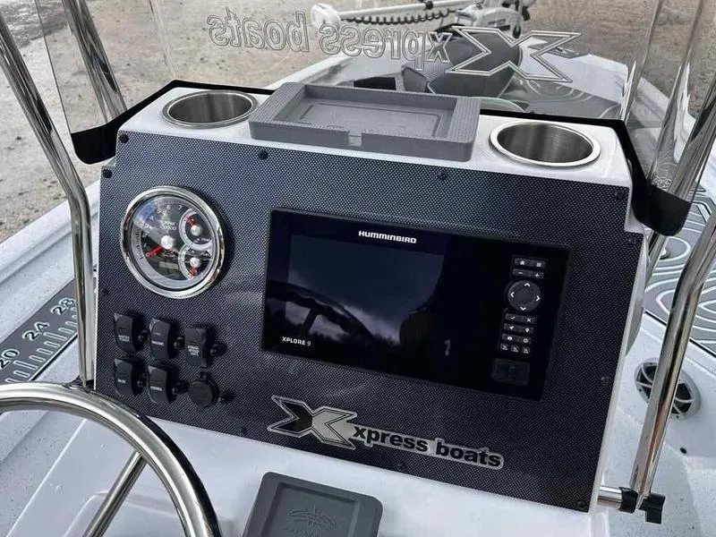 Slide: The Image of 2025 Xpress H20 BAY boat dashboard with gauges, controls, and cup holders. - 8