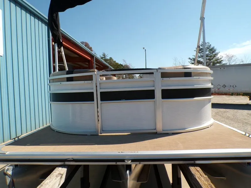 Slide: The Image of 2018 Crestliner 220 RALLY pontoon boat docked near a blue building. - 20
