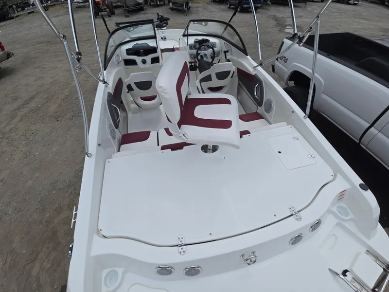 Slide: The Image of 2019 Tahoe 500 TF boat interior with red and white seating, parked on gravel. - 18