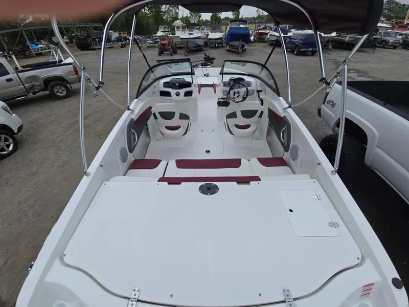 Slide: The Image of 2019 Tahoe 500 TF boat interior with seating and steering wheel, parked on gravel lot. - 19