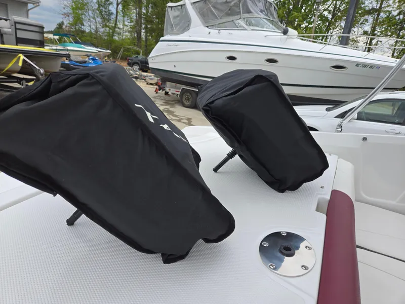 Slide: The Image of 2019 Tahoe 500 TF boat with covered seats, docked near a larger yacht. - 21
