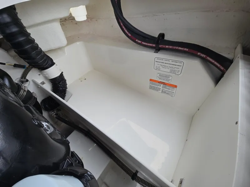 Slide: The Image of Engine compartment of a 2019 Tahoe 500 TF boat, showing hoses and warning labels. - 39
