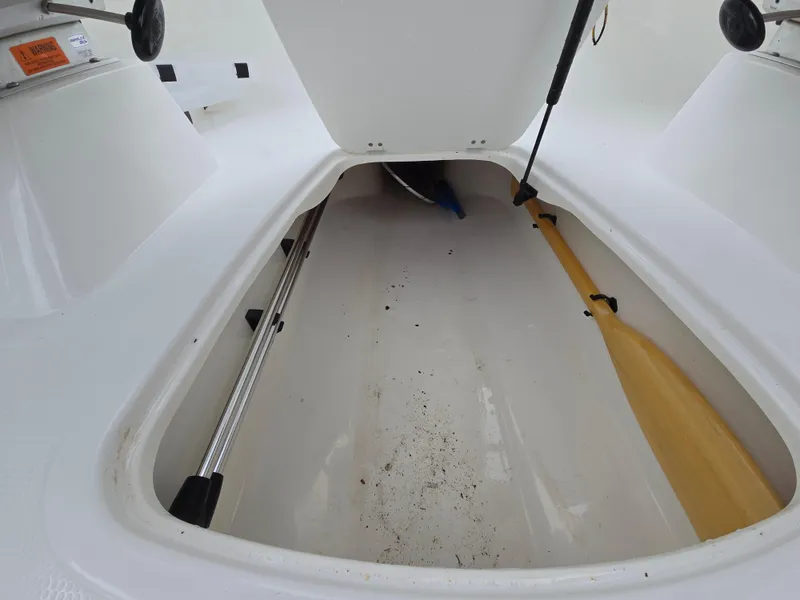 Slide: The Image of Open storage compartment of 2019 Tahoe 500 TF boat with paddle and equipment. - 42