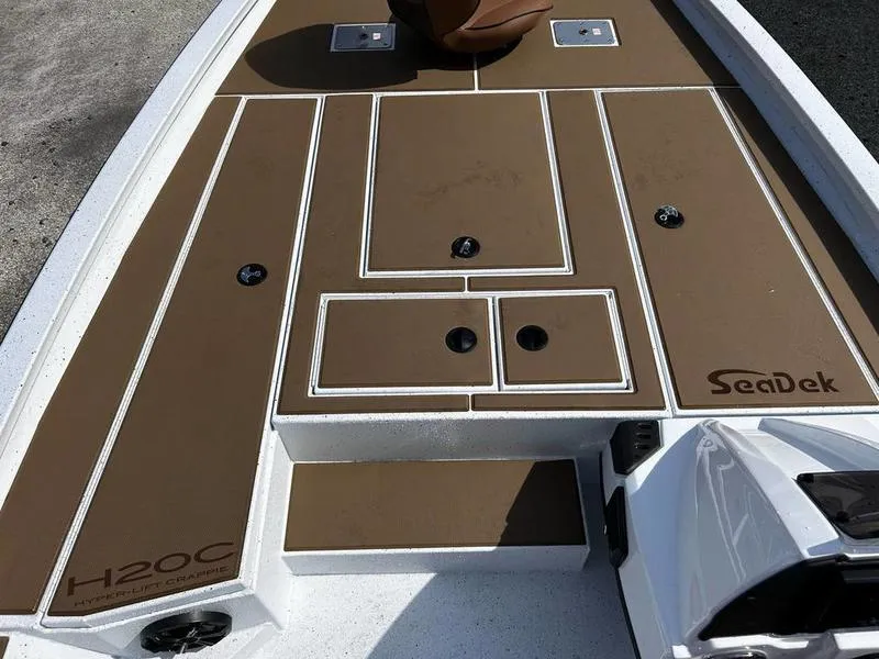 Slide: The Image of 2025 Xpress H20 Crappie boat deck with brown SeaDek flooring and storage compartments. - 13