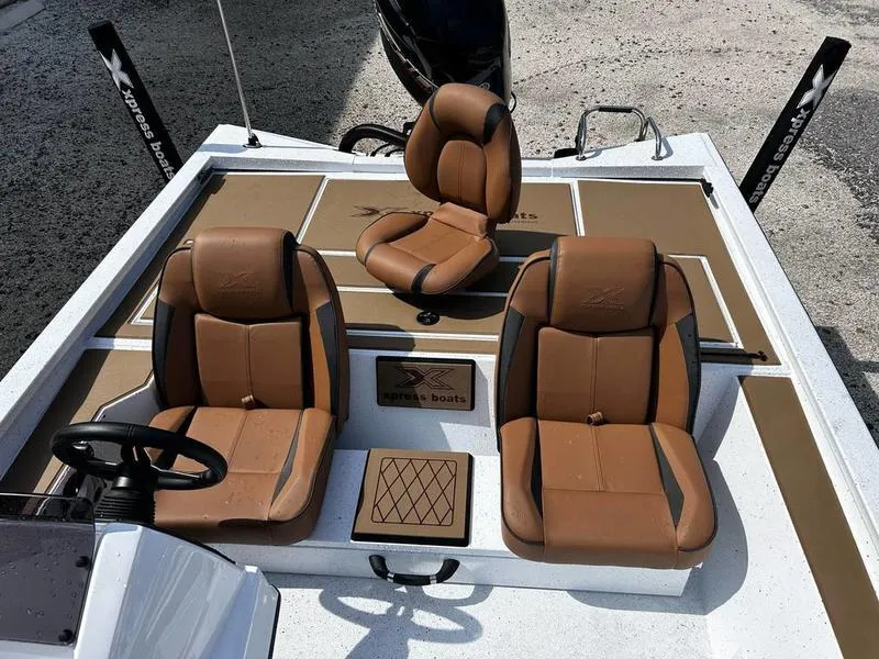 Slide: The Image of 2025 Xpress H20 Crappie boat interior with brown seats and steering wheel. - 9