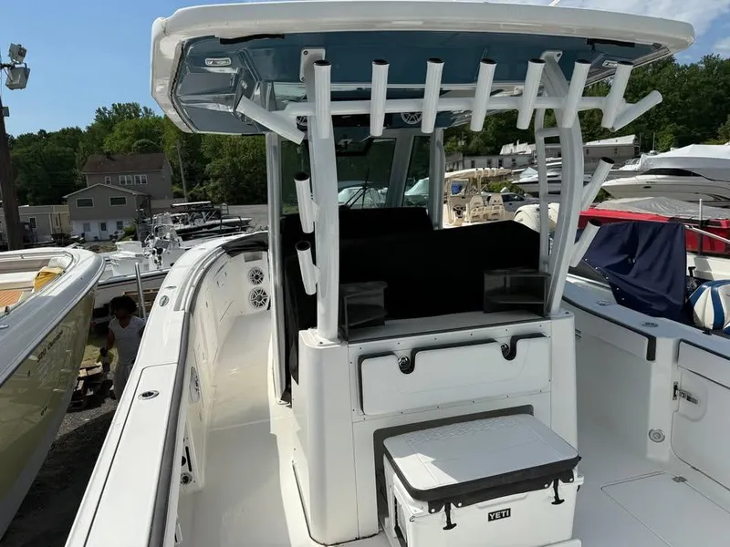 Slide: The Image of 2024 Crevalle 33 CSF boat with center console and rod holders, docked at a marina. - 9