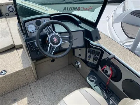 Slide: The Image of 2023 Alumacraft Trophy 185 boat interior with steering wheel and dashboard controls. - 2