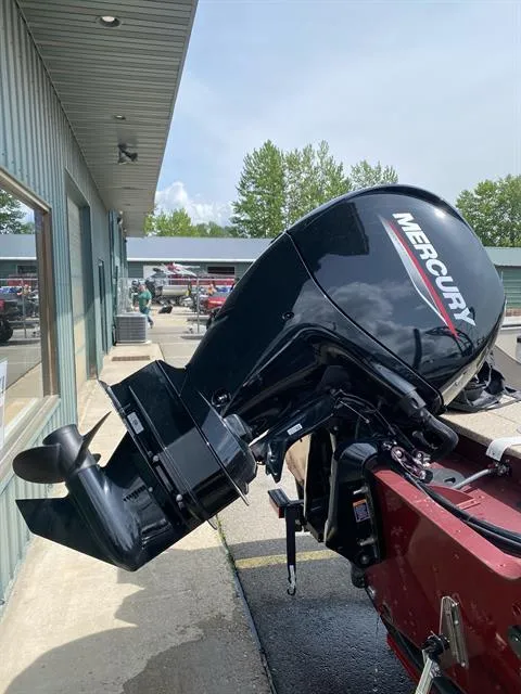 Slide: The Image of 2023 Alumacraft Trophy 185 with Mercury outboard motor, parked outside a building. - 4