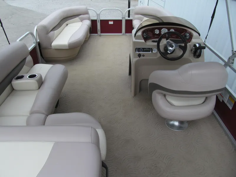 Slide: The Image of 2014 Sun Tracker Party Barge 20 DLX interior with beige seating and steering console. - 5