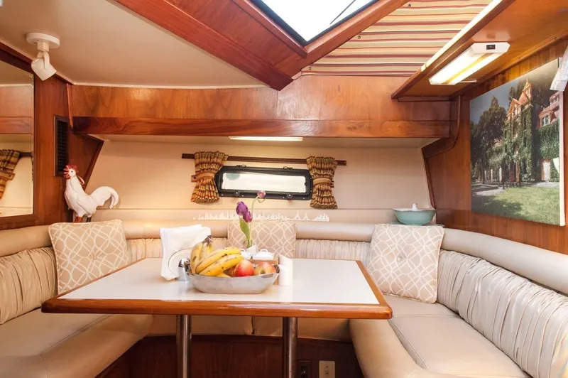 Slide: The Image of 1986 Californian 55 Cockpit Motor Yacht interior with cozy dining area and fruit centerpiece. - 11