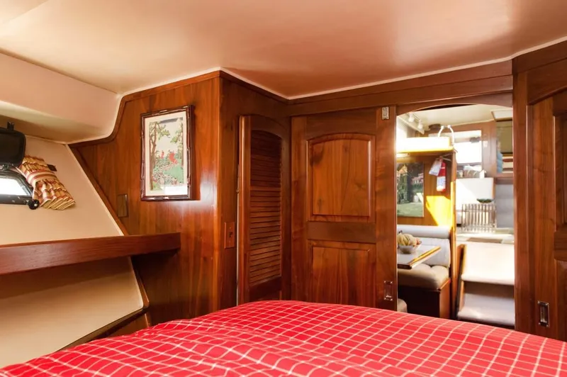Slide: The Image of 1986 Californian 55 Cockpit Motor Yacht interior with wood paneling and cozy bedroom. - 16