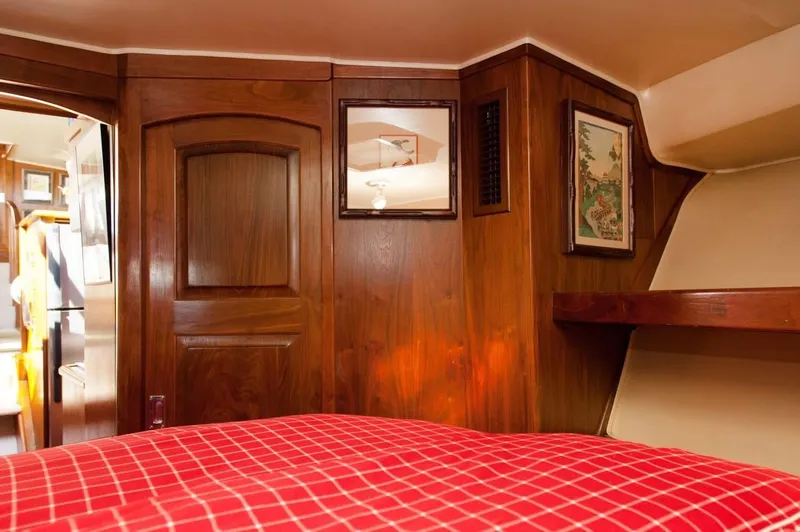 Slide: The Image of Interior of 1986 Californian 55 Cockpit Motor Yacht with wood paneling and red checkered bedding. - 17