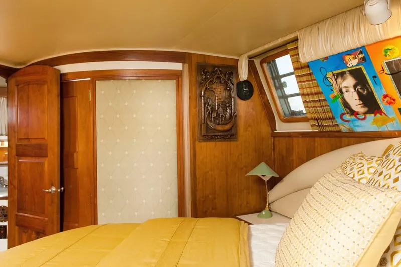 Slide: The Image of Luxurious bedroom interior of 1986 Californian 55 Cockpit Motor Yacht with wood paneling and artwork. - 21