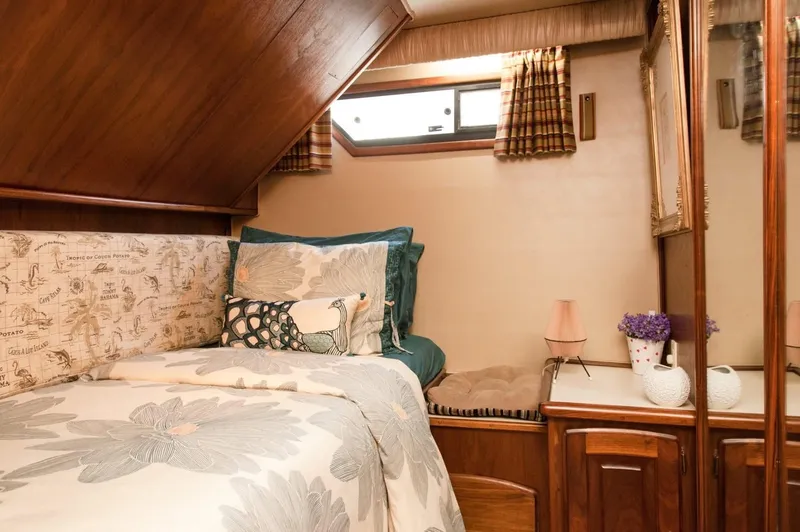 Slide: The Image of Cozy cabin interior of 1986 Californian 55 Cockpit Motor Yacht with floral bedding and wood accents. - 22