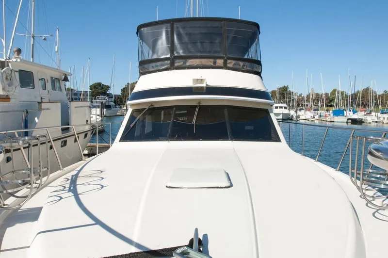 Slide: The Image of 1986 Californian 55 Cockpit Motor Yacht docked in a marina, surrounded by other boats. - 24