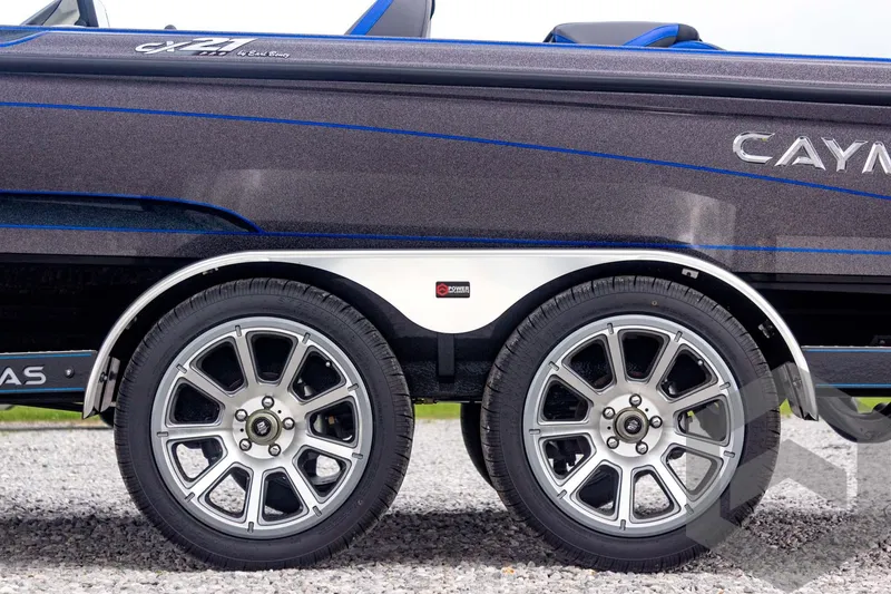 Slide: The Image of 2025 Caymas CX 21 PRO boat trailer with dual alloy wheels on gravel. - 10