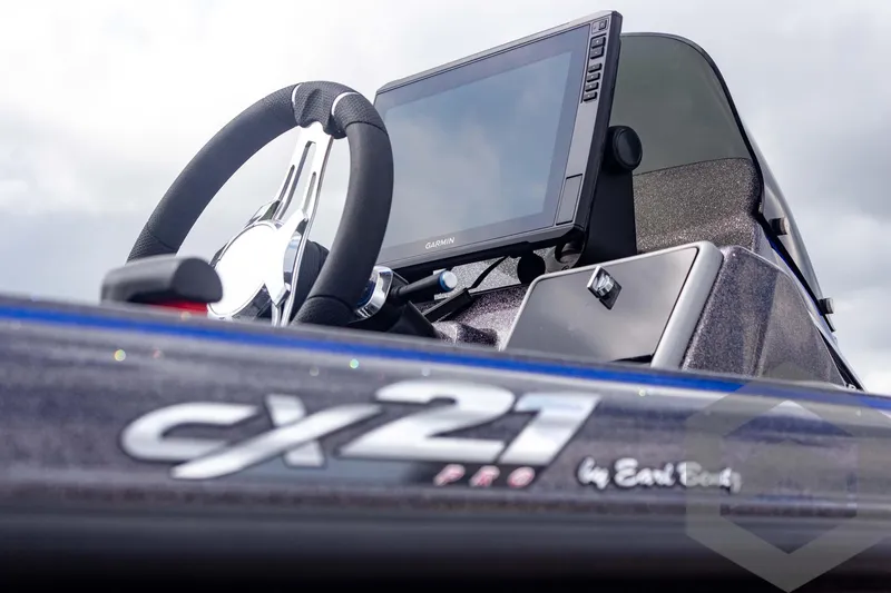 Slide: The Image of 2025 Caymas CX 21 PRO boat dashboard with steering wheel and display screen. - 22
