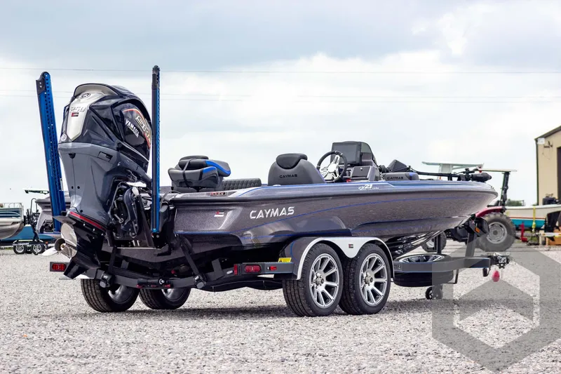Slide: The Image of 2025 Caymas CX 21 PRO boat on trailer, parked outdoors, showcasing sleek design and powerful engine. - 4