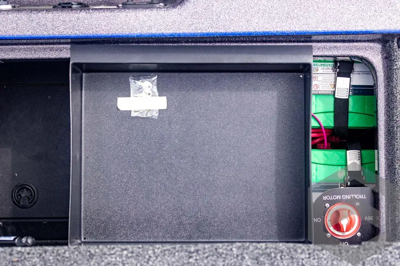 Slide: The Image of 2025 Caymas CX 21 PRO boat storage compartment with battery and trolling motor switch. - 49