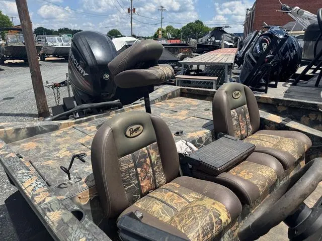 Slide: The Image of 2015 Ranger RT 188 boat with camo seats and Mercury outboard motor, parked outdoors. - 10