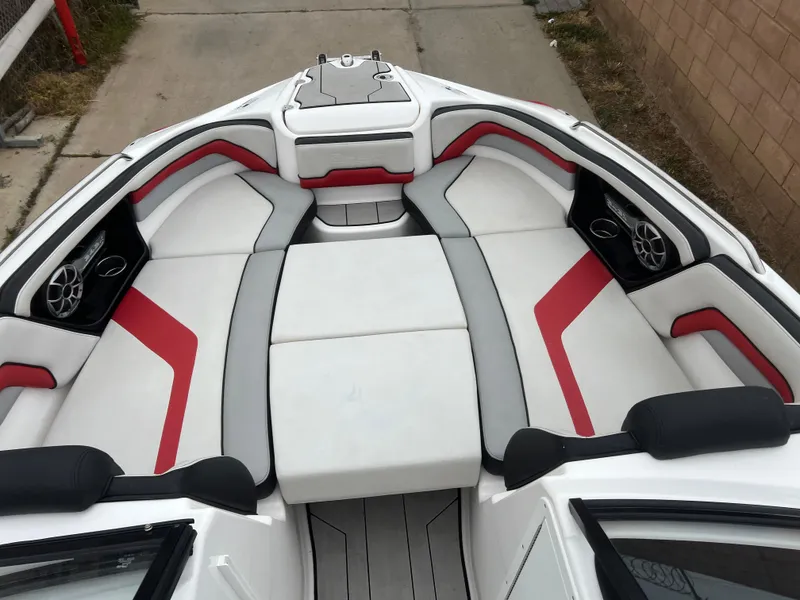 Slide: The Image of 2020 Yamaha Boats 242X interior with red and gray seating, featuring speakers and storage. - 11