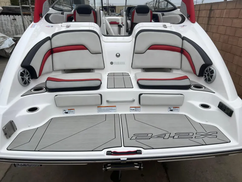 Slide: The Image of 2020 Yamaha Boats 242X, rear view with seating and deck, featuring red and gray accents. - 15