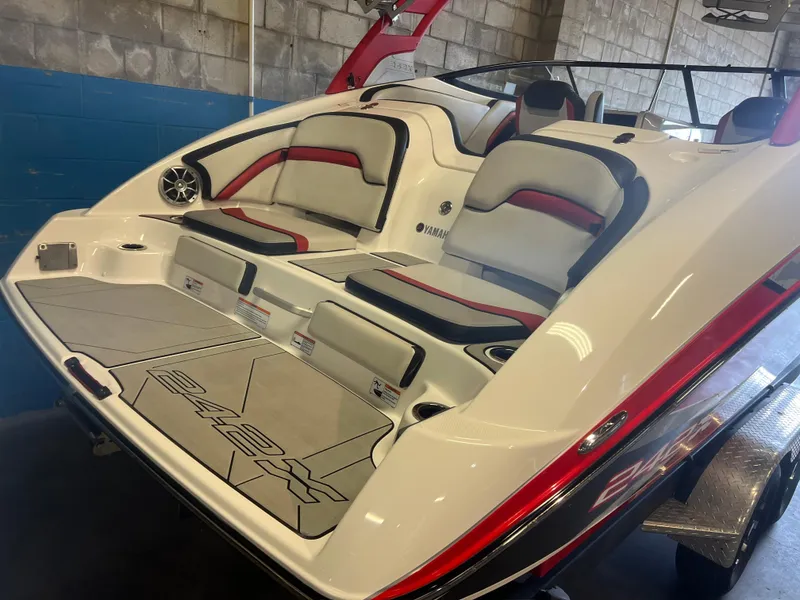 Slide: The Image of 2020 Yamaha Boats 242X interior with red and black accents, showcasing seating and deck design. - 16