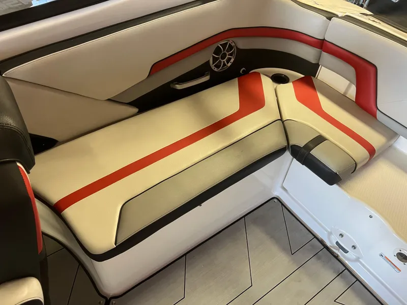 Slide: The Image of 2020 Yamaha Boats 242X interior seating with red and beige upholstery, featuring a speaker. - 19