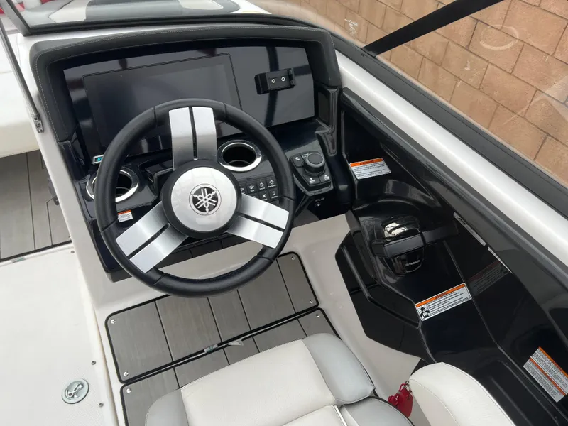 Slide: The Image of 2020 Yamaha Boats 242X cockpit with steering wheel and control panel. - 21