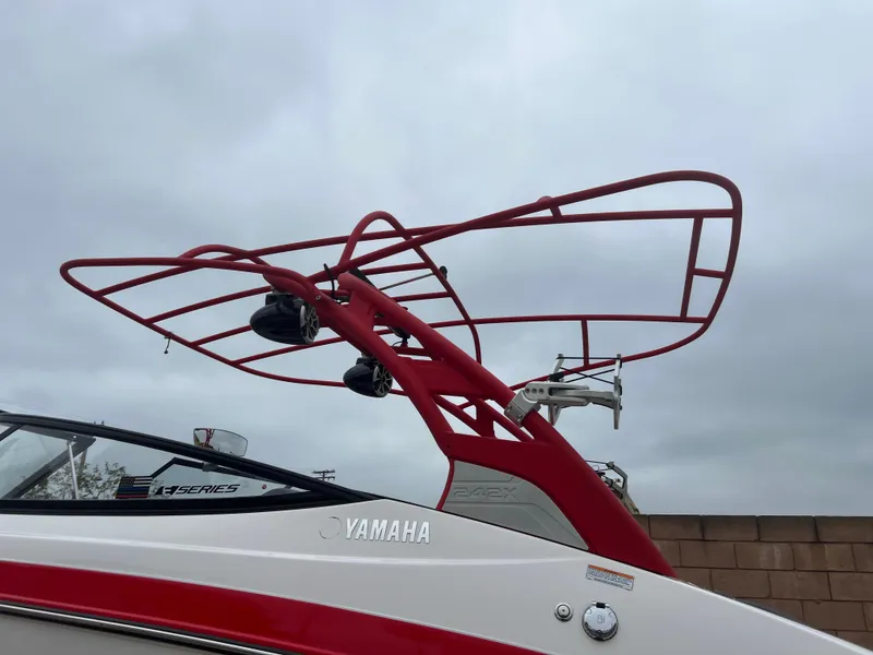 Slide: The Image of 2020 Yamaha Boats 242X with red wakeboard tower against cloudy sky. - 28