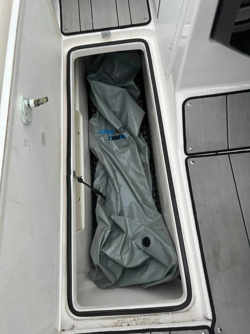 Slide: The Image of Storage compartment on a 2020 Yamaha Boats 242X with a folded cover inside. - 33