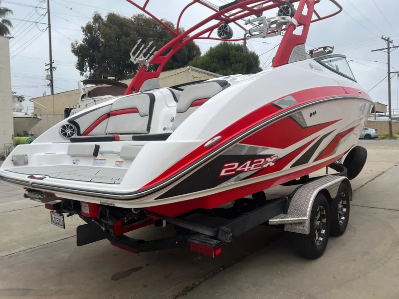 Slide: The Image of 2020 Yamaha Boats 242X on trailer, red and white design, parked outdoors. - 4