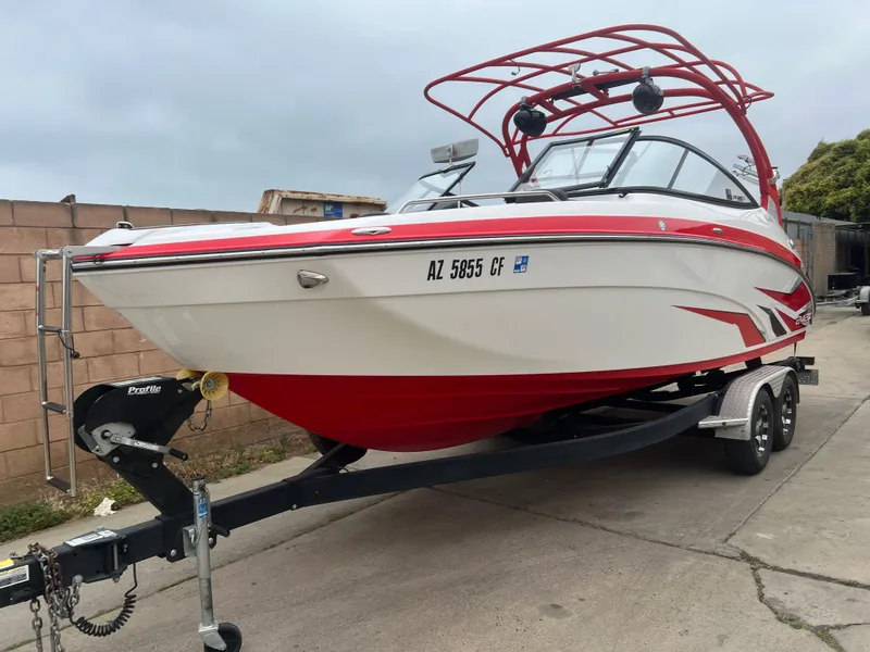 Slide: The Image of 2020 Yamaha Boats 242X on trailer, red and white design, parked outdoors. - 8