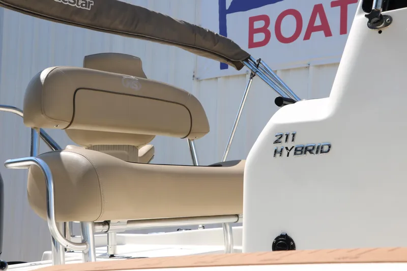 Slide: The Image of 2020 NauticStar 211 Hybrid boat with beige seating and branding detail. - 14