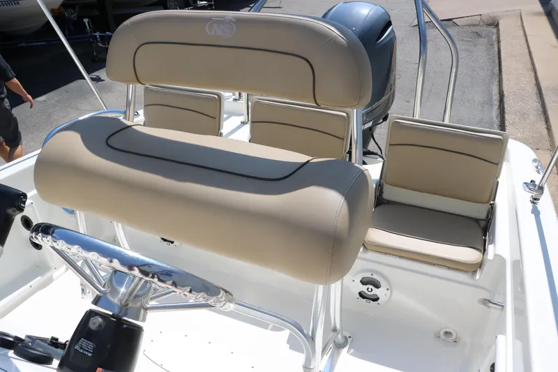 Slide: The Image of 2020 NauticStar 211 Hybrid boat interior with beige seating and steering wheel. - 27