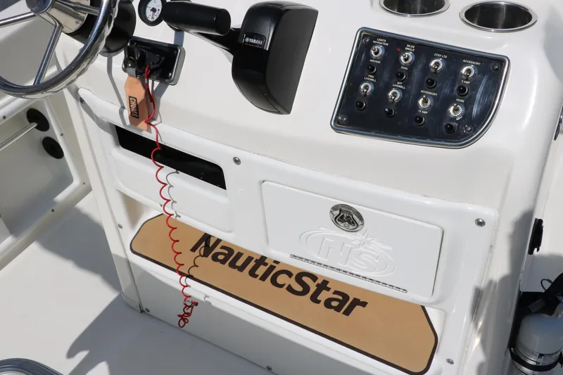 Slide: The Image of 2020 NauticStar 211 Hybrid boat console with controls and logo. - 43