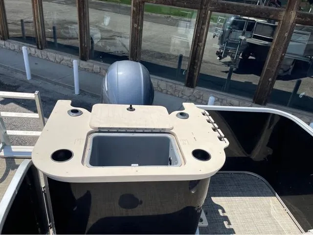 Slide: The Image of 2019 SunCatcher V 322CC boat with open storage compartment and motor, viewed from above. - 11
