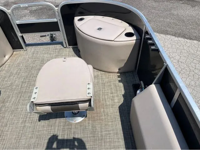 Slide: The Image of 2019 SunCatcher V 322CC boat interior with beige seating and storage compartments. - 16