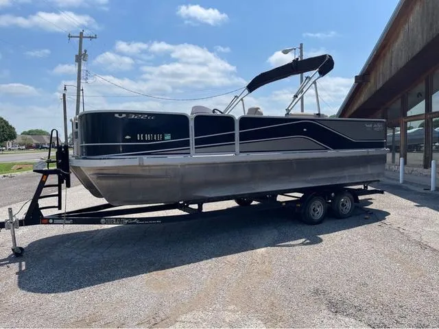 Slide: The Image of 2019 SunCatcher V 322CC pontoon boat on trailer, parked outdoors under a clear sky. - 2