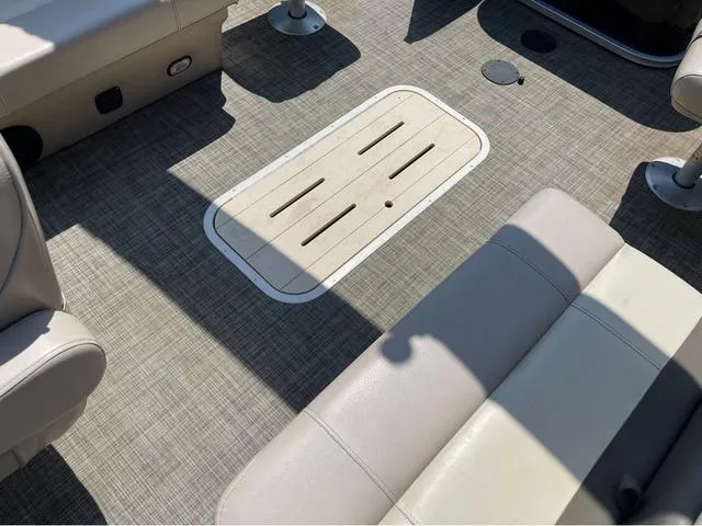 Slide: The Image of 2019 SunCatcher V 322CC boat interior with beige seating and textured flooring. - 9