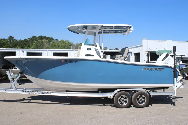 The Image of 2023 Sea Pro 239 Center Console boat on a trailer, parked outdoors. - 1