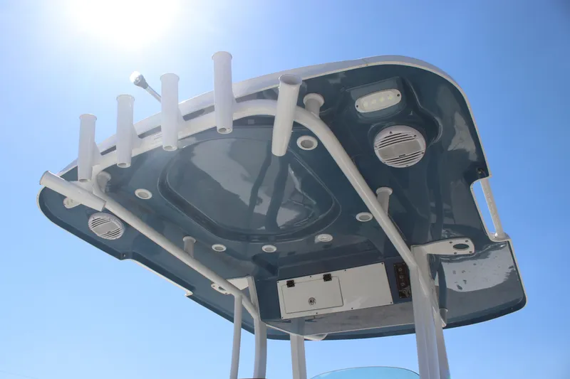 Slide: The Image of 2023 Sea Pro 239 Center Console T-top with rod holders under clear blue sky. - 13