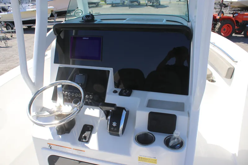 Slide: The Image of 2023 Sea Pro 239 Center Console boat dashboard with steering wheel and controls. - 14