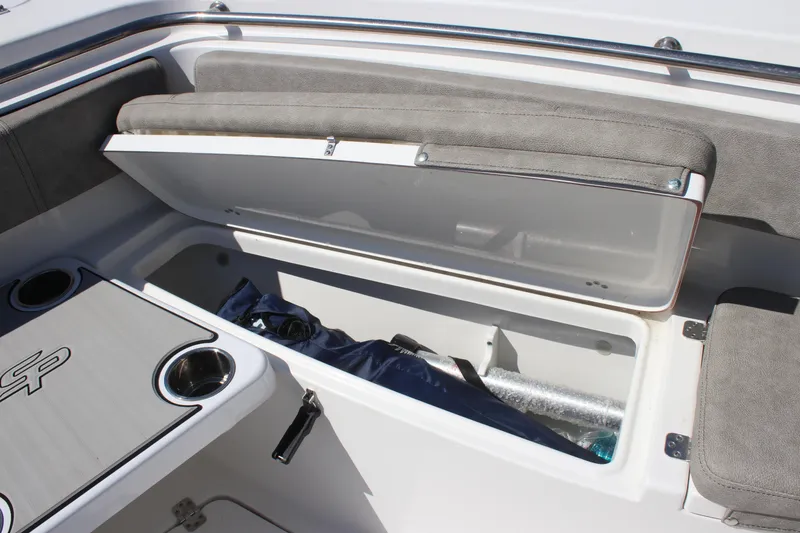 Slide: The Image of 2023 Sea Pro 239 Center Console boat storage compartment with open lid and seating area. - 22