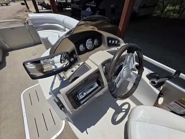 Slide: The Image of 2013 Bennington 2275GLW pontoon boat interior with white seating and steering console. - 11