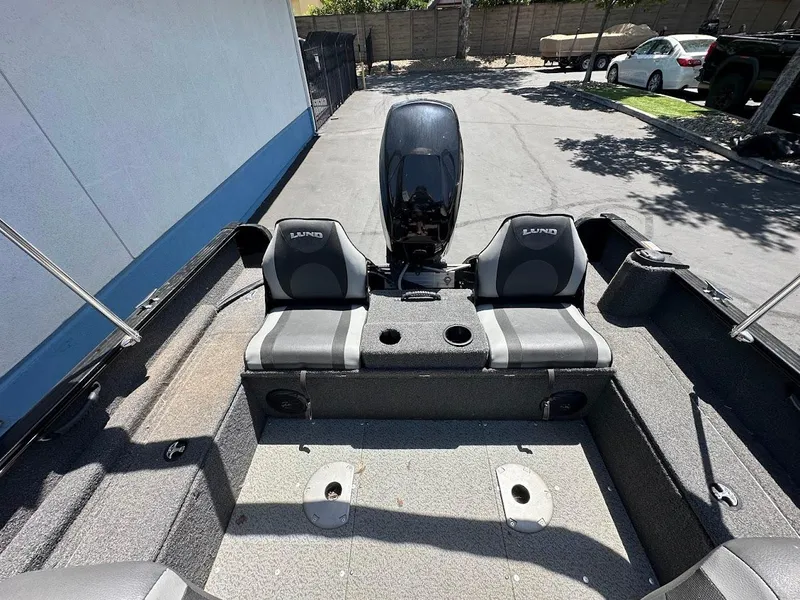 Slide: The Image of 2022 Lund 1650 Rebel XL Sport boat interior with dual seats and motor. - 11