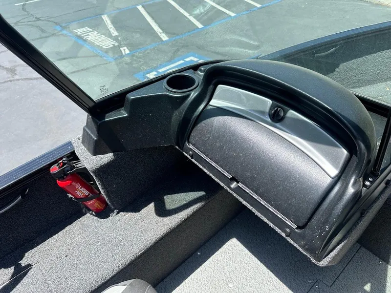 Slide: The Image of 2022 Lund 1650 Rebel XL Sport boat interior with open glove compartment and fire extinguisher. - 19