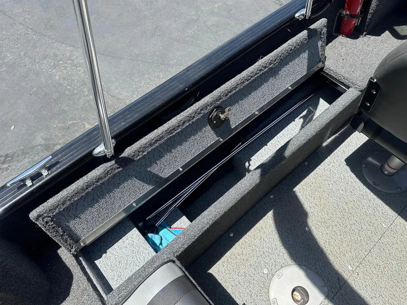 Slide: The Image of 2022 Lund 1650 Rebel XL Sport boat storage compartment, open and carpeted. - 23