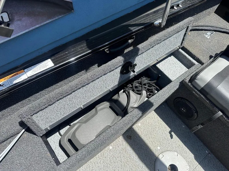 Slide: The Image of 2022 Lund 1650 Rebel XL Sport boat storage compartment with equipment inside. - 24